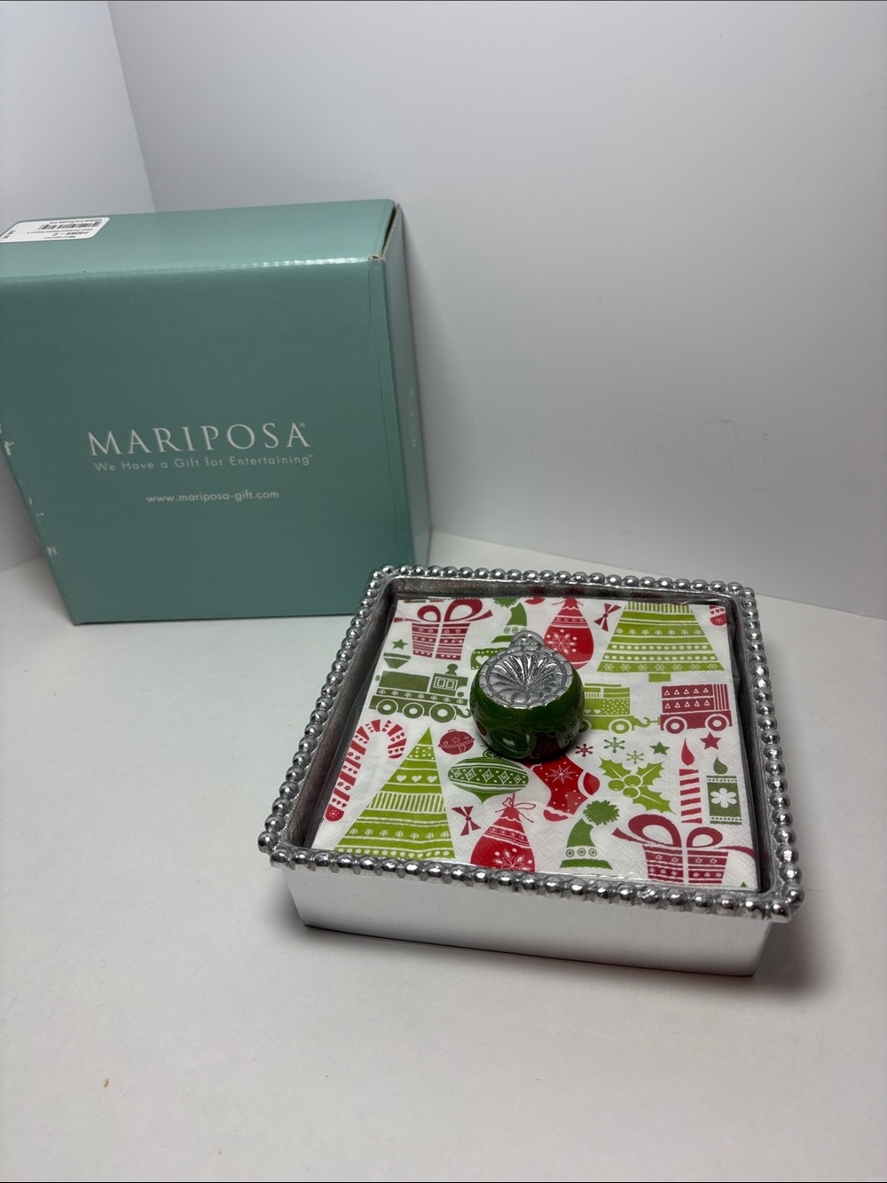Mariposa Green and Red Holiday napkins, napkin holder and napkin weight.